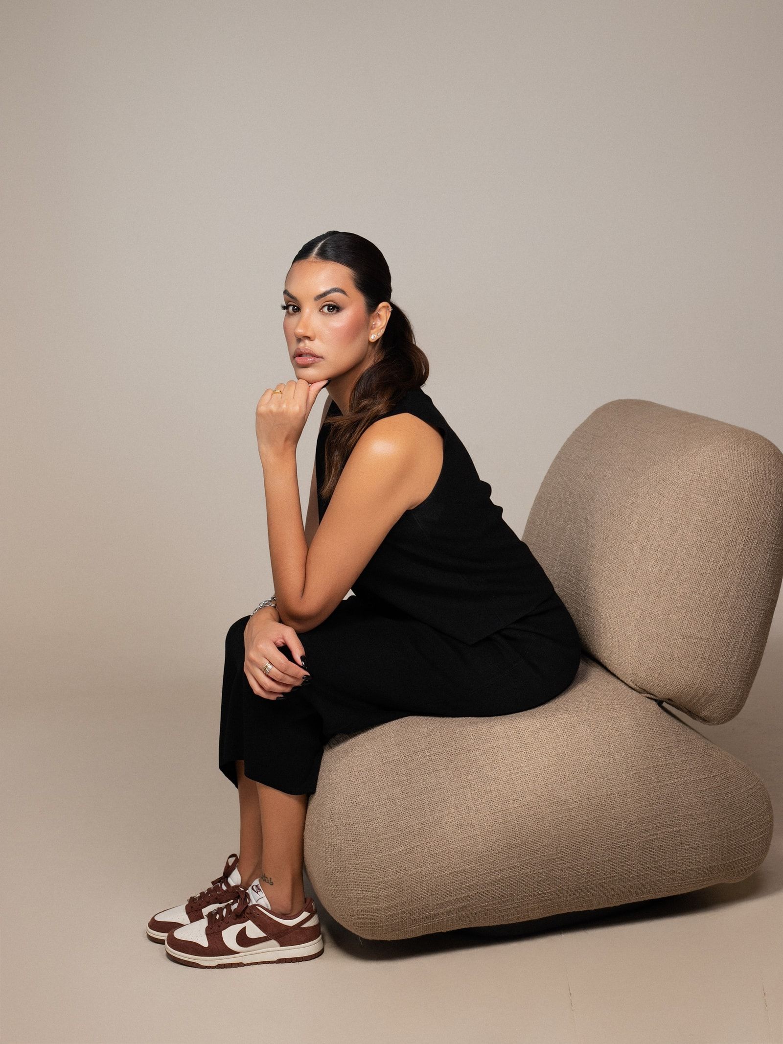 Ana Luísa Andrade, psicóloga, sentada em uma poltrona, com expressão serena, olhando para a câmera.